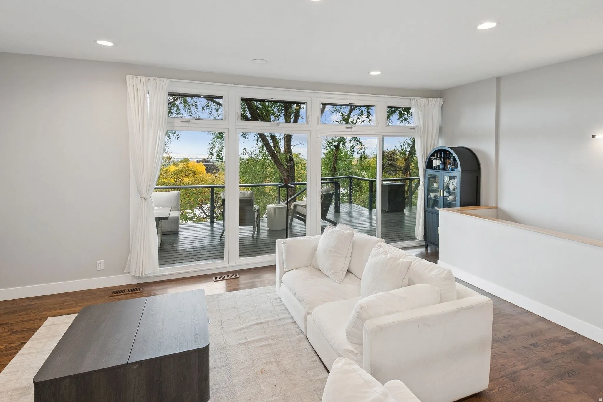 Spacious living area featuring expansive glass doors opening to an outdoor deck