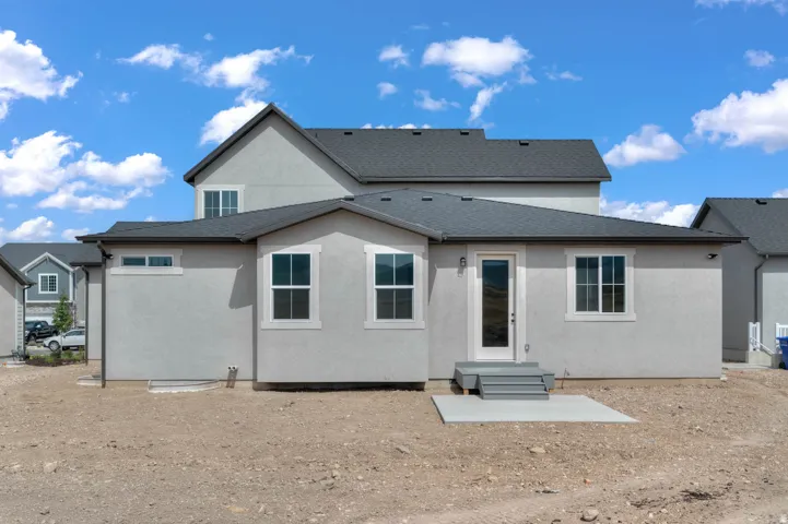 Light gray stucco exterior with white-framed windows, a glass-panel door, and a gray shingle roof
