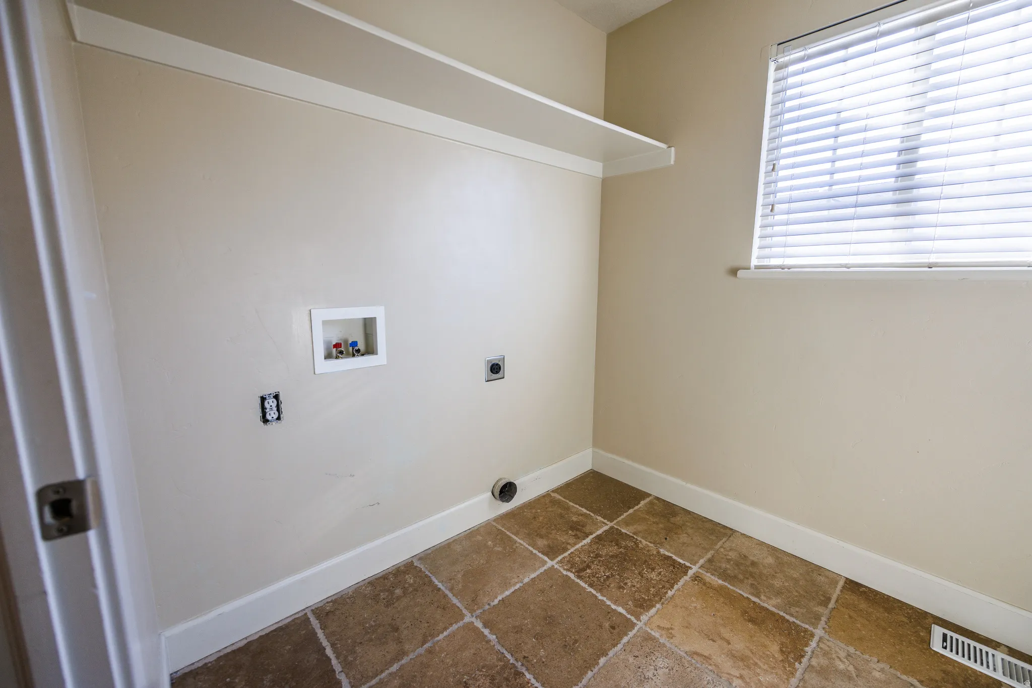 Dedicated laundry area featuring a utility sink connection, dryer vent, and electrical outlet