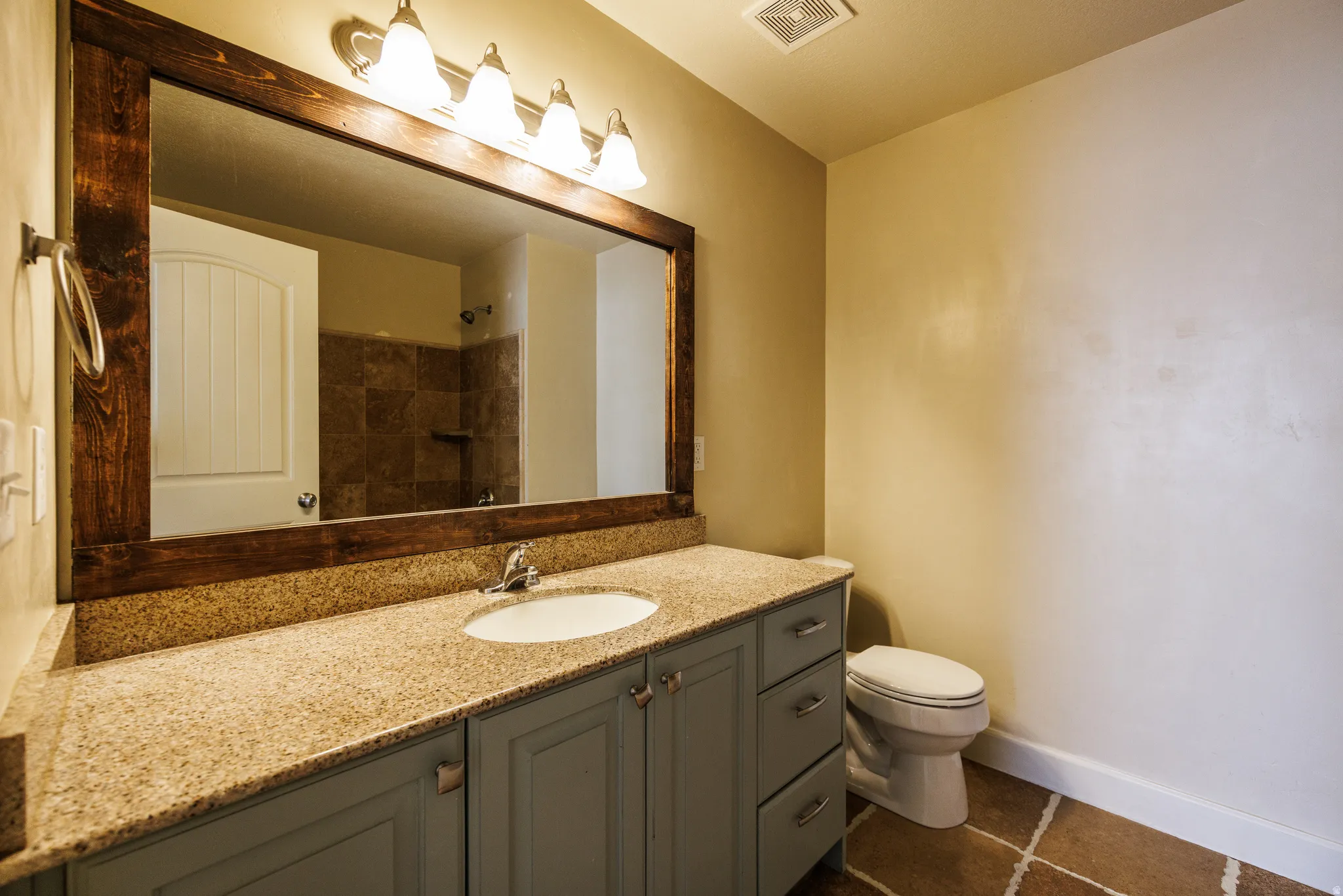 Bathroom vanity featuring a light-colored granite countertop, an undermount sink, and light blue cabinetry with brushed nickel pulls