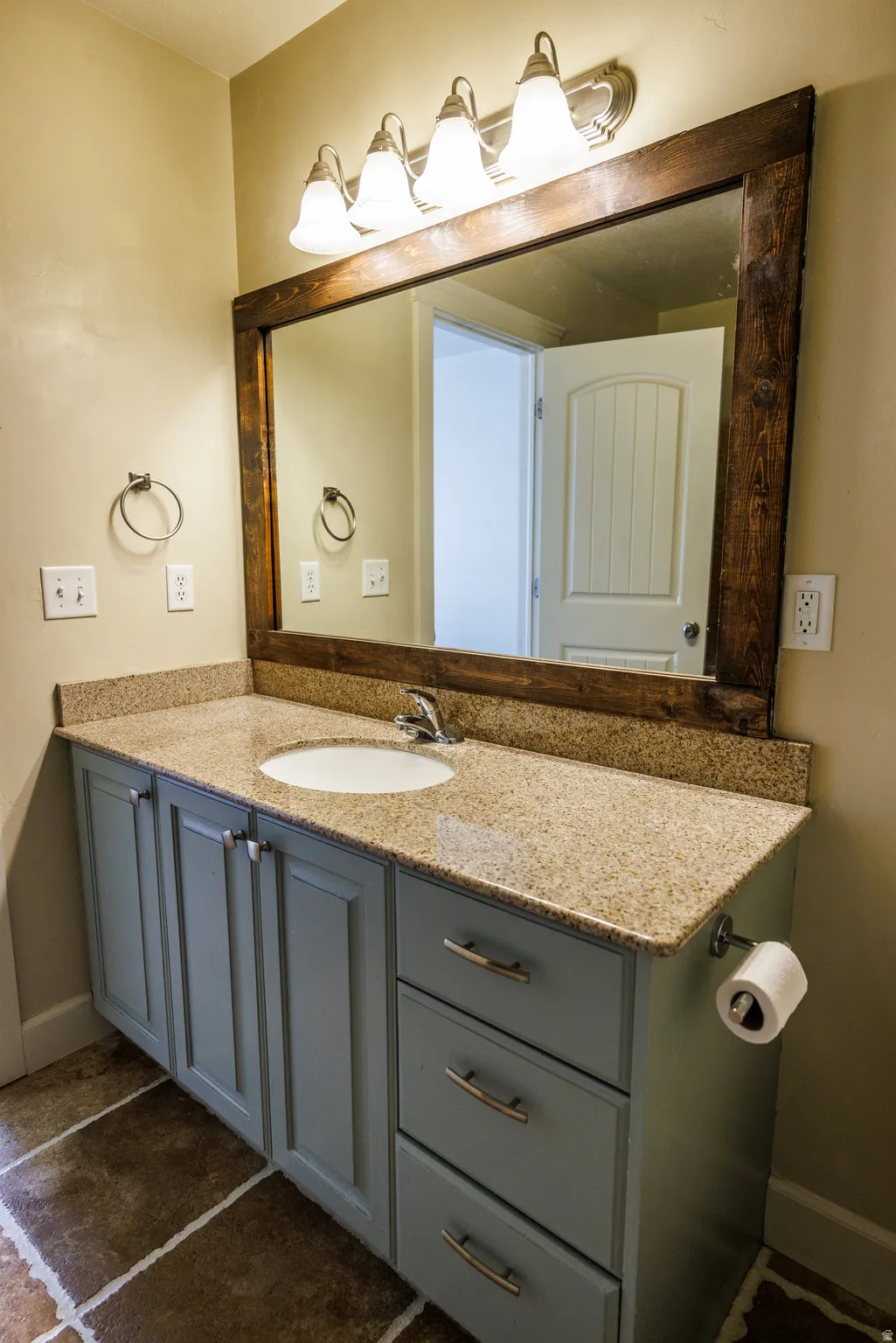 Vanity with a granite countertop, integrated sink, and brushed nickel faucet