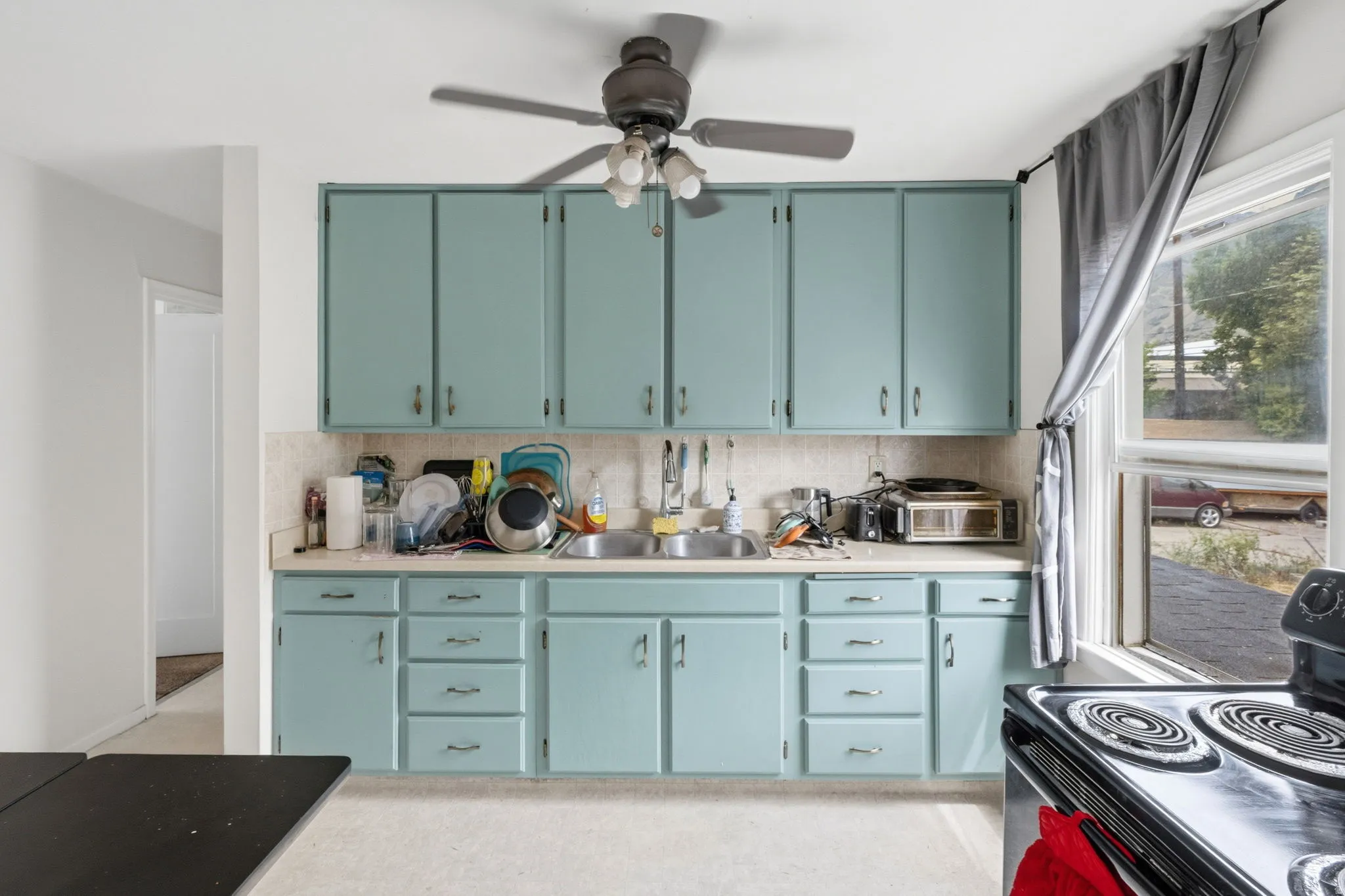 Kitchen featuring abundant cabinetry, a double basin sink, and a built-in electric range