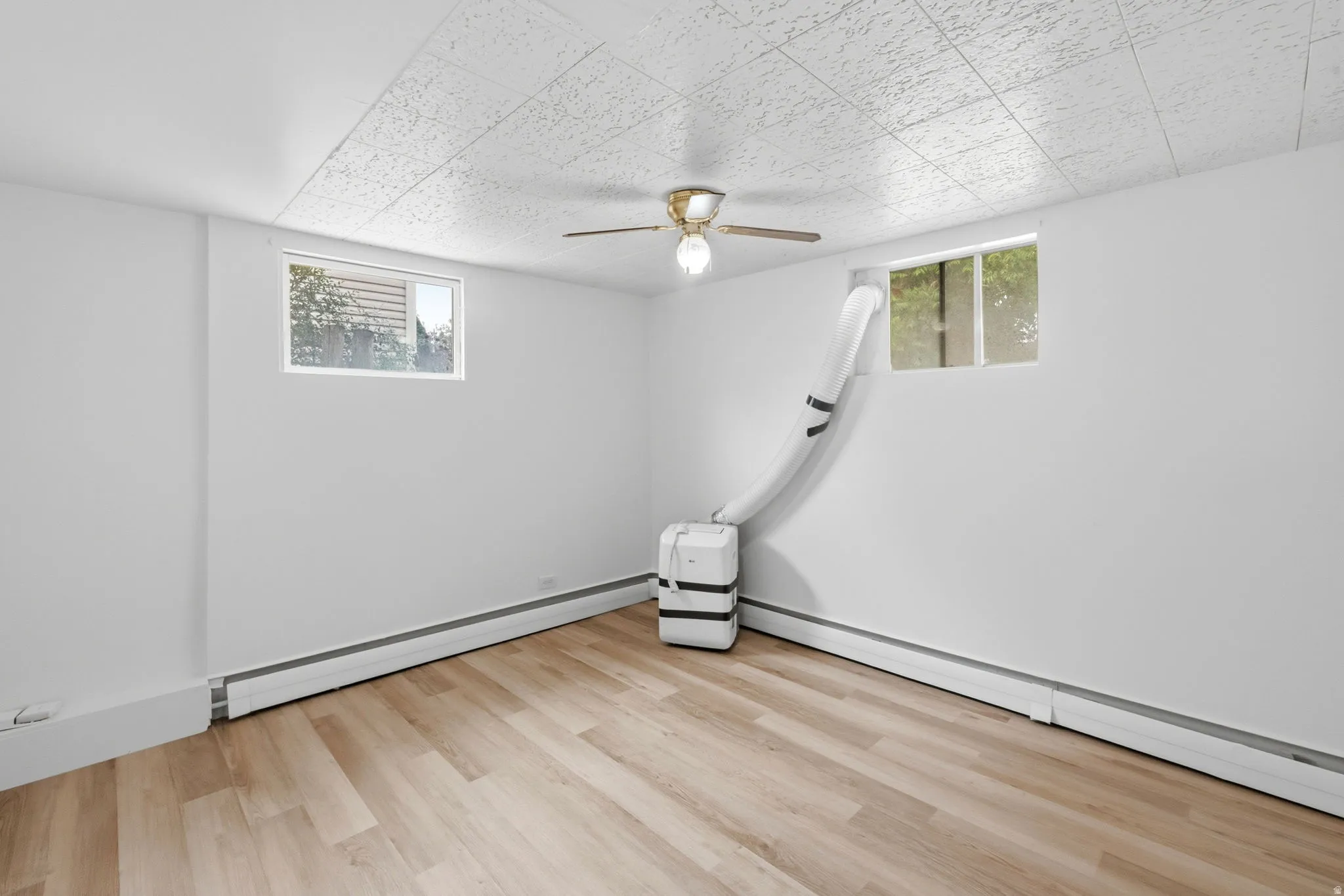 Room featuring wood-finish flooring, white painted walls, and a textured ceiling