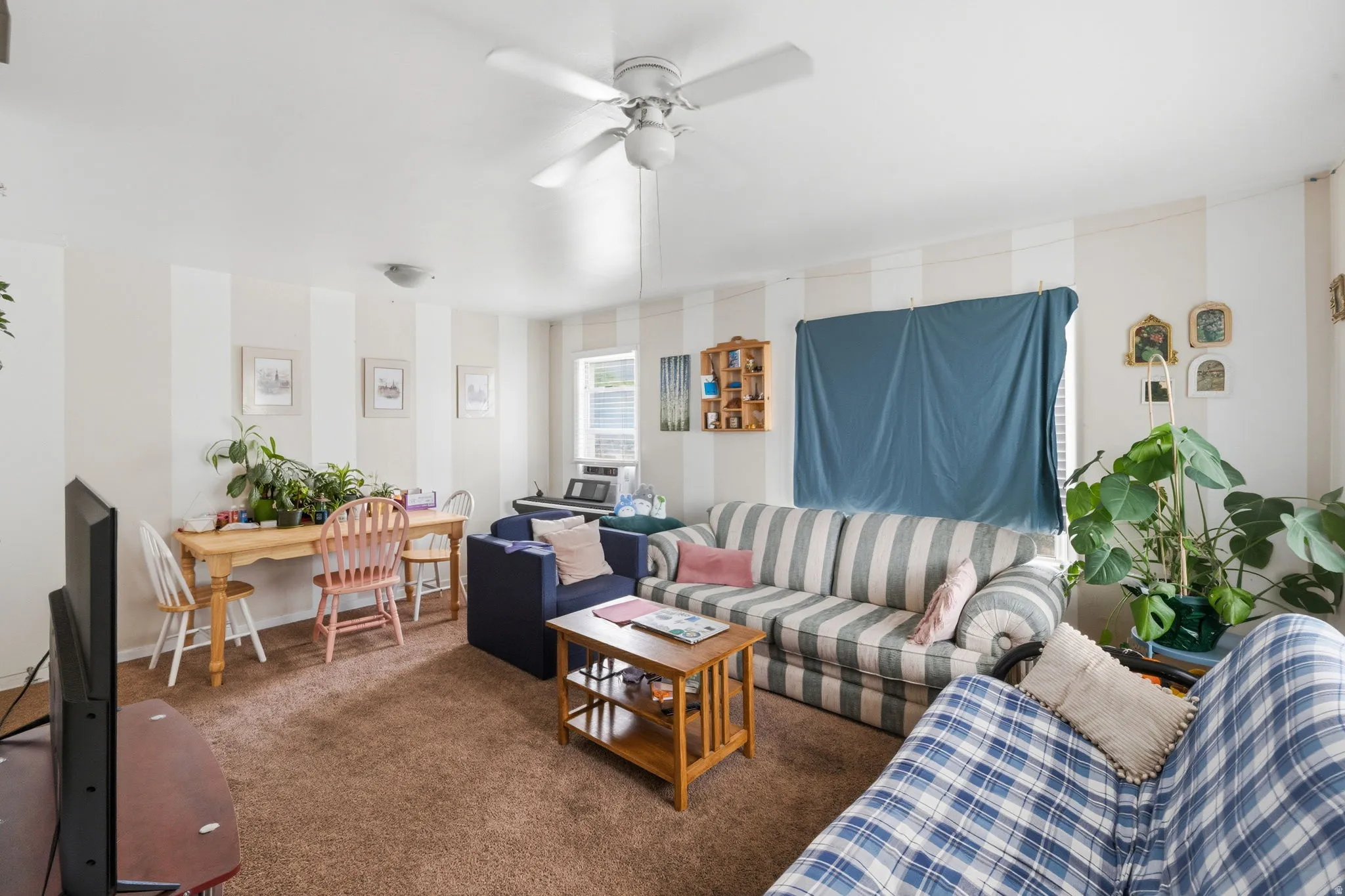 Carpeted living area featuring white and beige striped walls