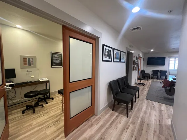 Private office space featuring a pocket door with frosted glass panels, wood-finish flooring, and recessed lighting