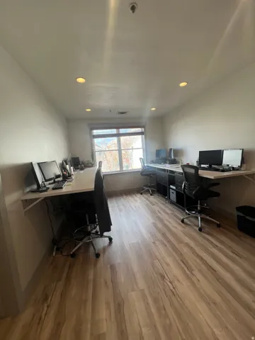Spacious room featuring wood-finish flooring, recessed ceiling lighting, and a large window