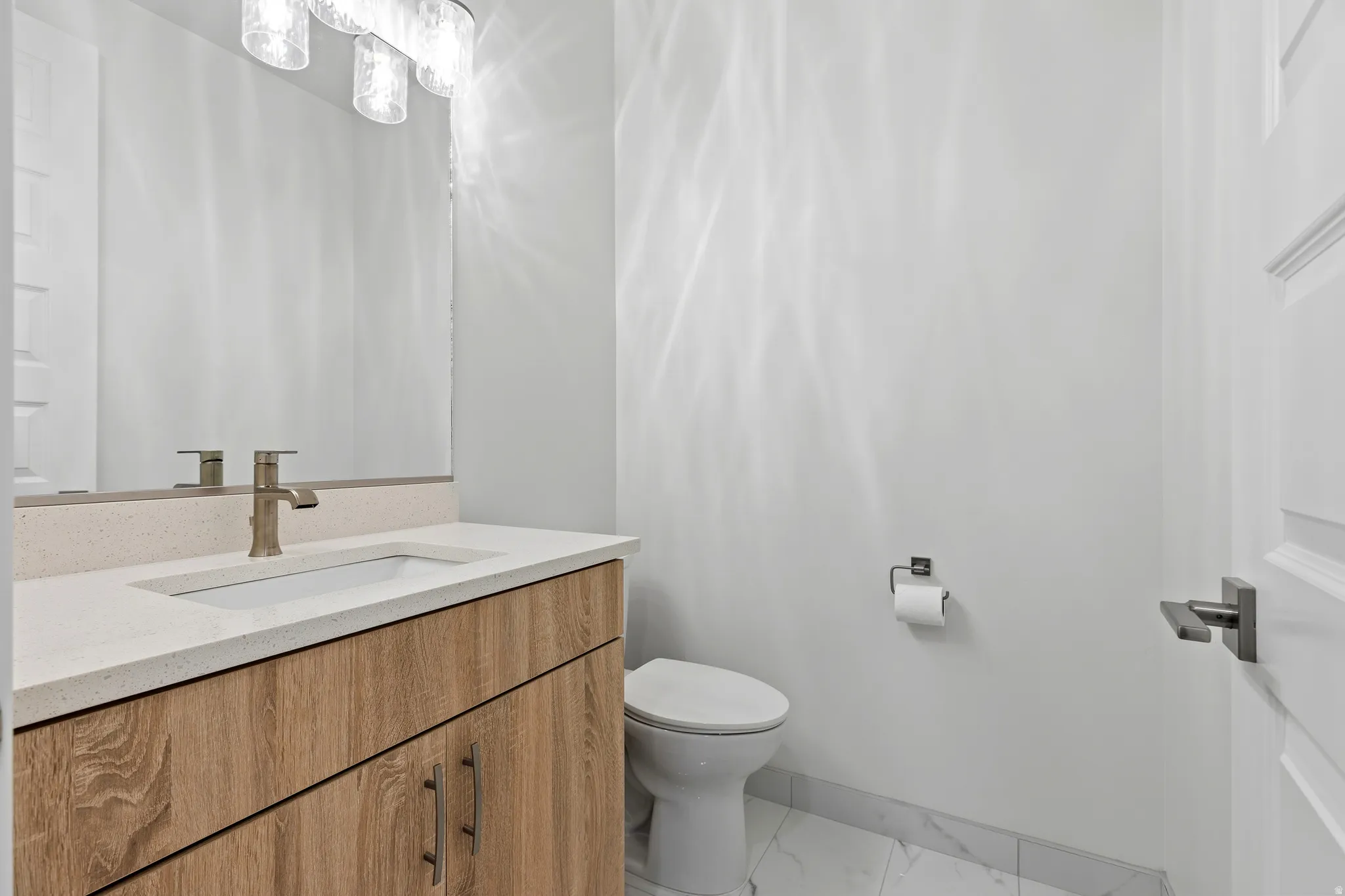 Contemporary vanity with a light wood-finish base, integrated basin, and brushed nickel faucet