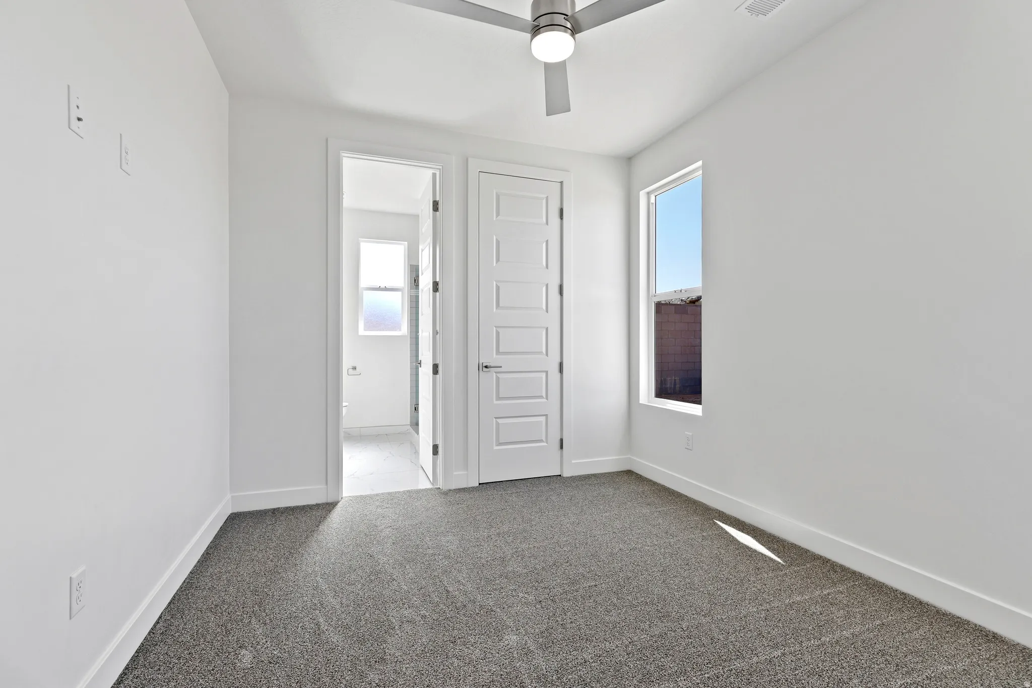 Bedroom featuring a neutral color palette, gray carpet, white baseboards, and a modern ceiling fan