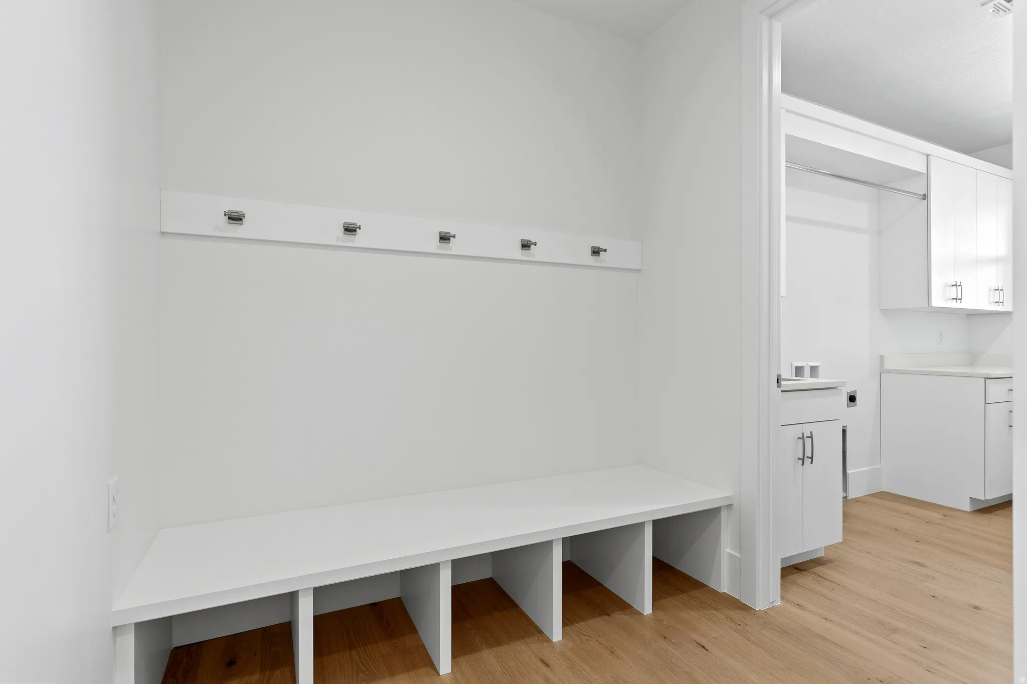 Built-in bench seating with cubby storage, featuring wall-mounted hooks