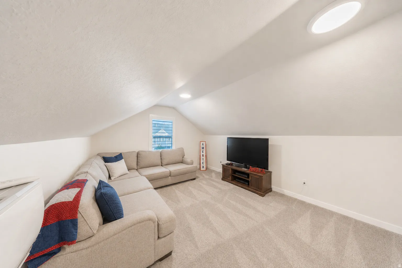 Bonus room area featuring a sloped ceiling, recessed lighting, and a window