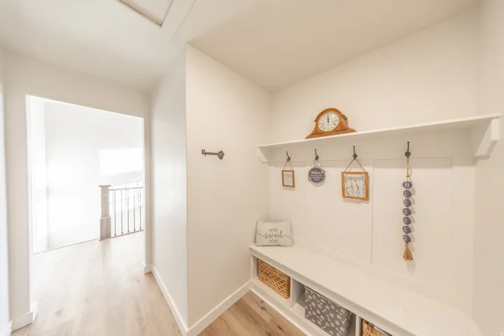 Built-in bench seating with cubby storage, featuring a board and batten accent wall with integrated coat hooks and an overhead shelf