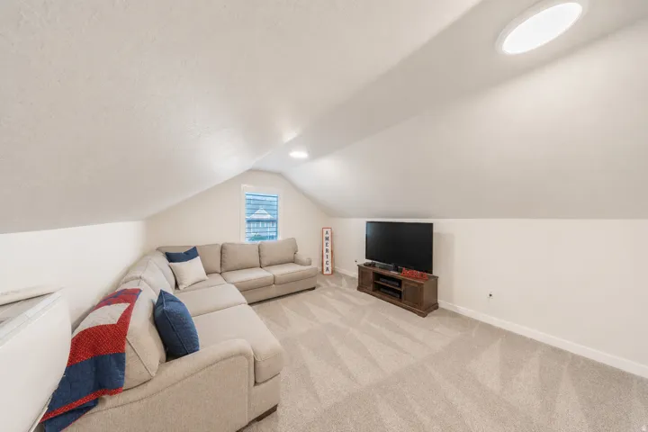 Bonus room area featuring a sloped ceiling, recessed lighting, and a window