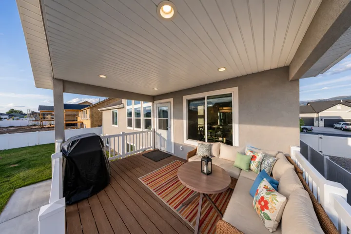 Covered deck featuring wood-finish decking, recessed lighting, and white vinyl railings