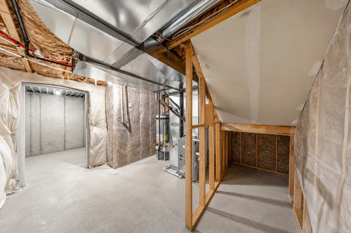 Unfinished basement with concrete flooring and exposed ceiling ductwork