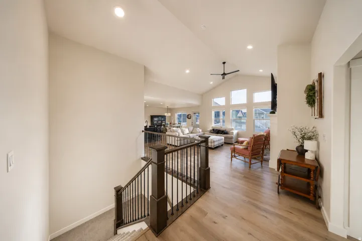 Open-concept living space featuring vaulted ceilings, recessed lighting, a modern ceiling fan, and extensive window arrays