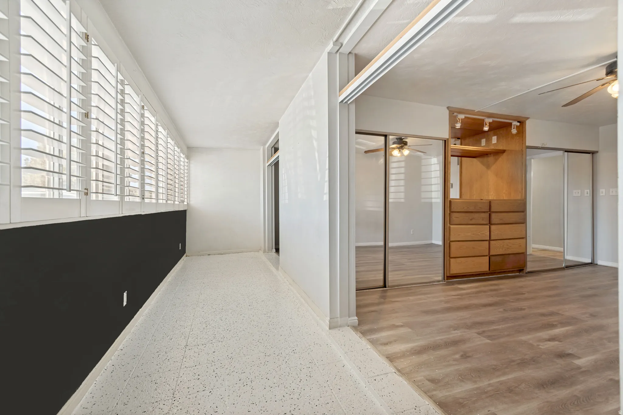 Sunroom featuring white plantation shutters and terrazzo flooring