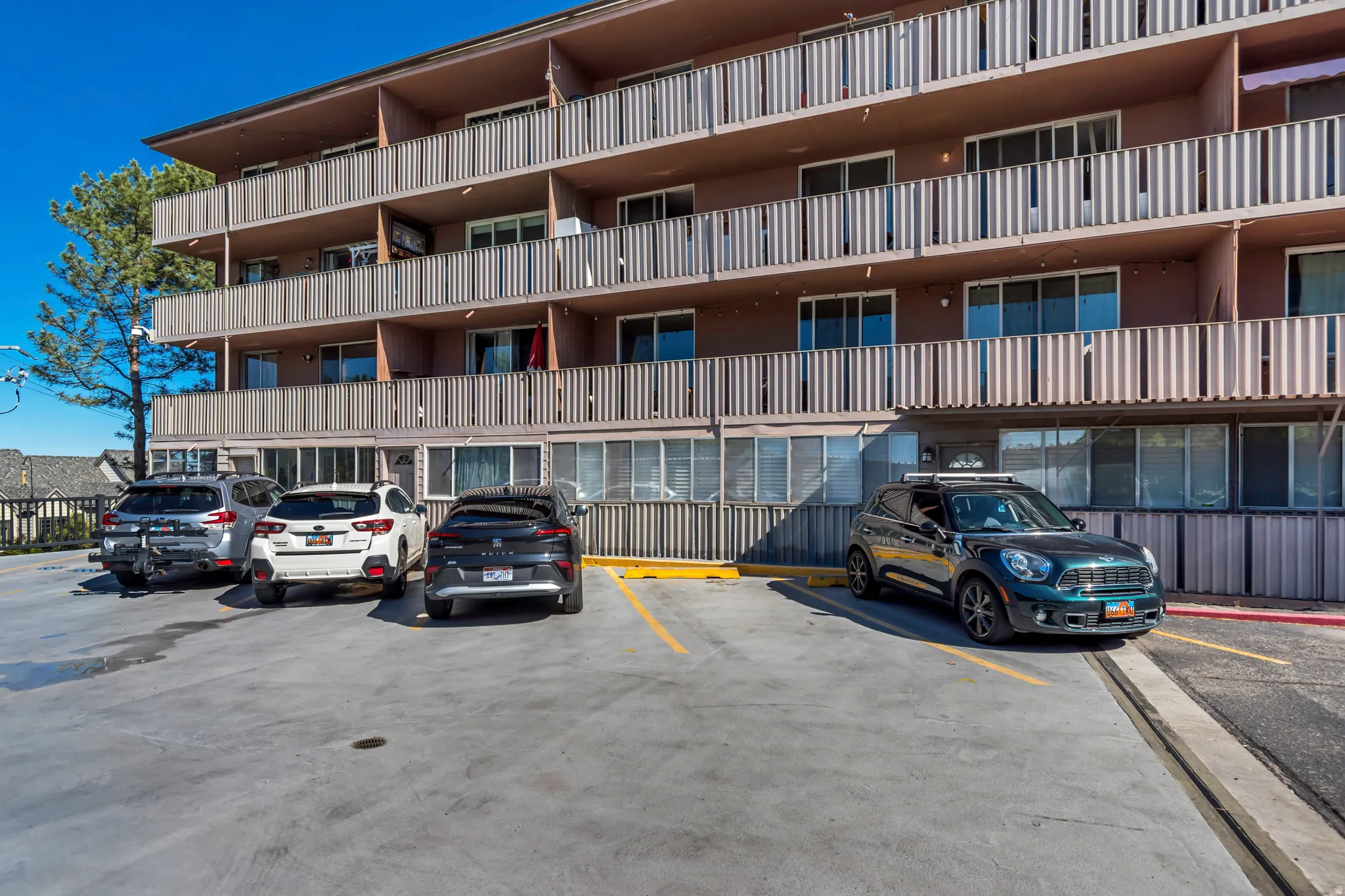 Multi-story building exterior with individual balconies featuring vertical panel railings