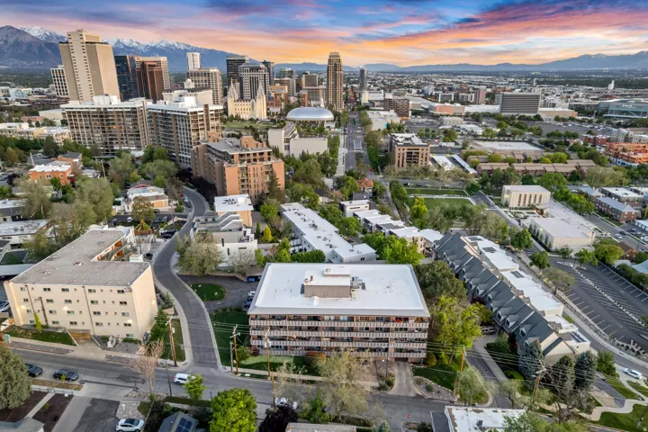 Aerial perspective of a metropolitan area with a prominent multi-story residential building featuring multiple balconies