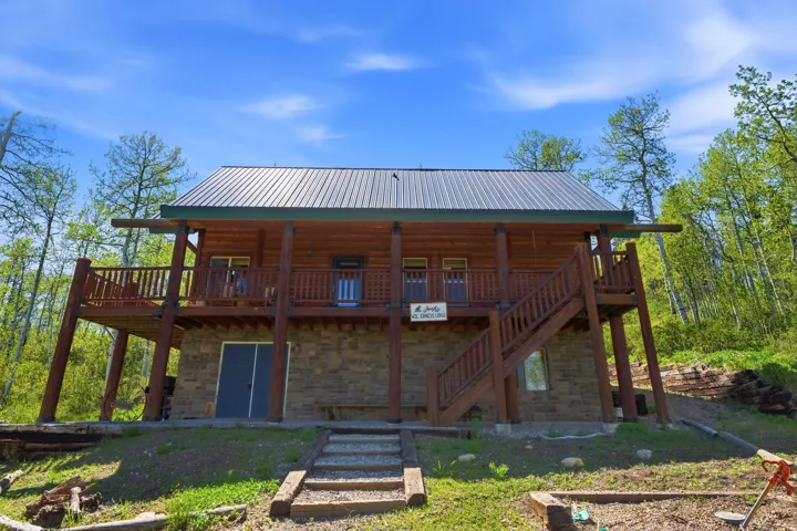 Log cabin exterior with a metal roof and stone foundation