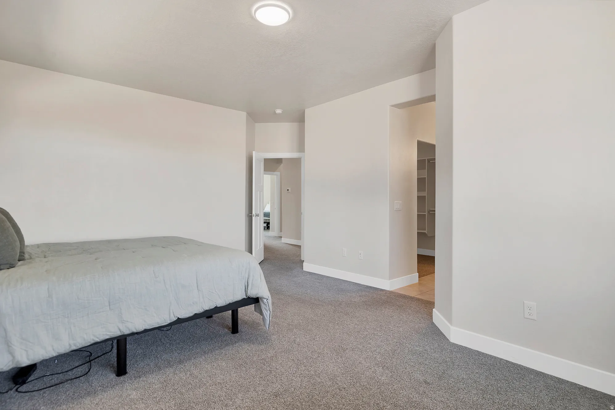 Bedroom featuring light gray carpet flooring and white baseboards