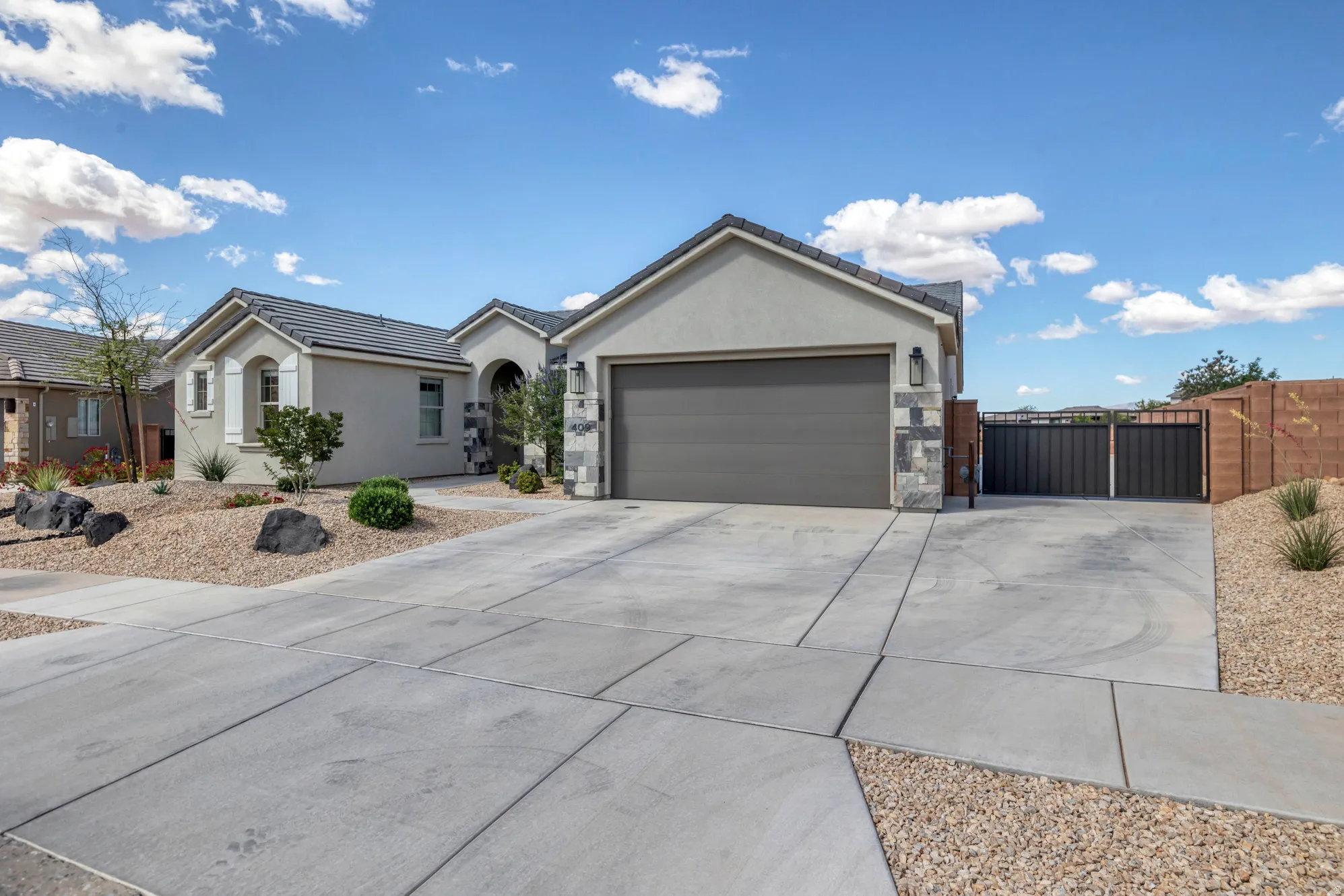 Contemporary stucco exterior with a gray tile roof and a two-car garage
