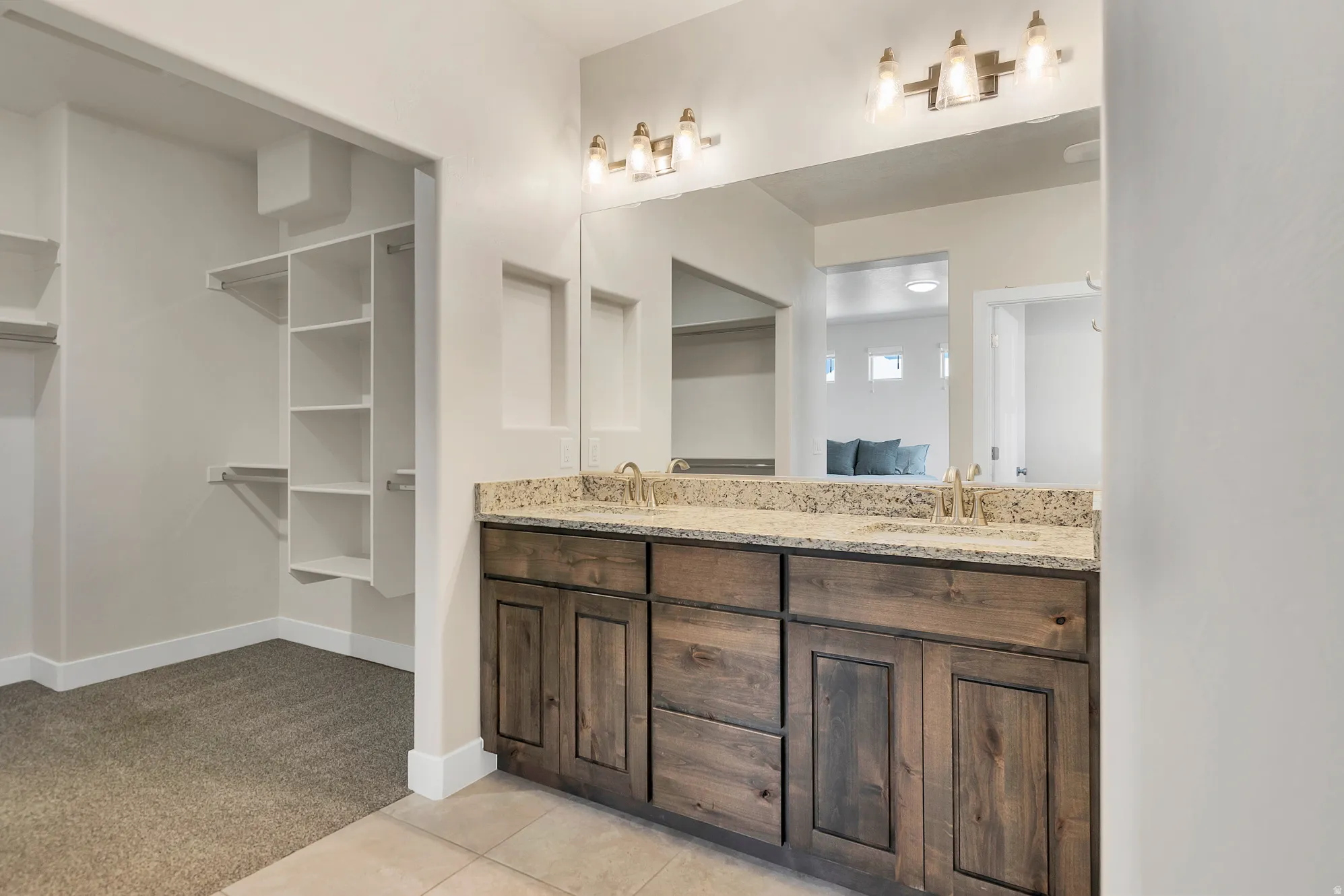 Dual vanity with undermount sinks, stone countertop, and wood-finish cabinetry