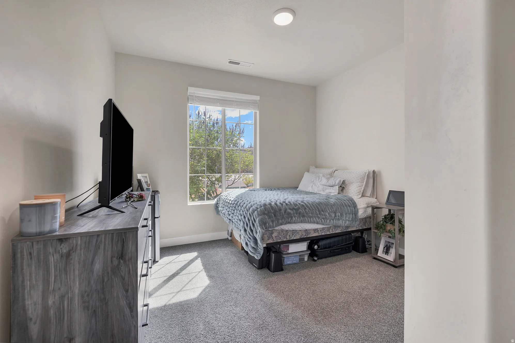 Carpeted room featuring a double-pane window with blinds, a recessed ceiling light fixture, and light-toned wall finishes