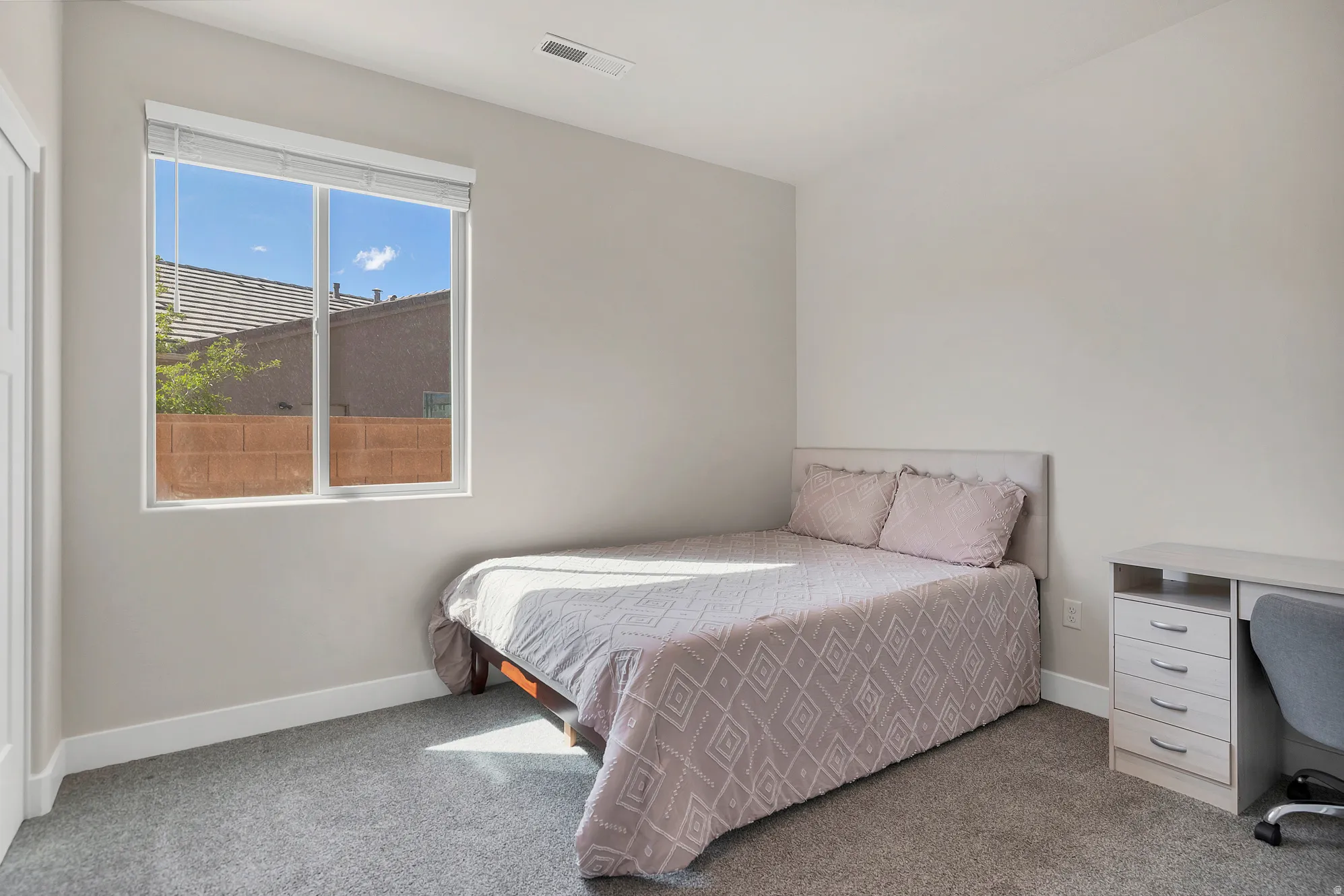 Bedroom featuring light gray walls, gray carpeting, a single window with white blinds, and white baseboards