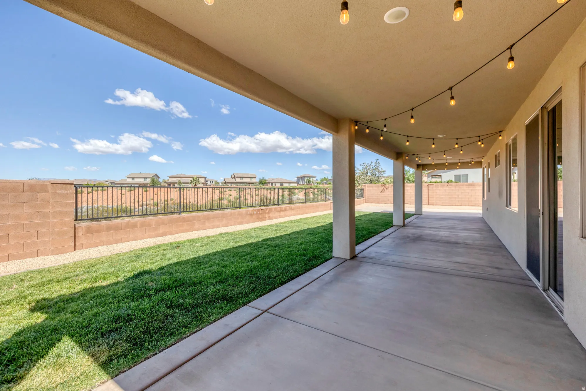 Covered patio featuring a concrete surface, overhead lighting, and multiple support columns