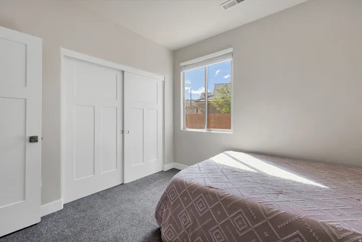 Room featuring a large window, sliding paneled closet doors, and light gray walls