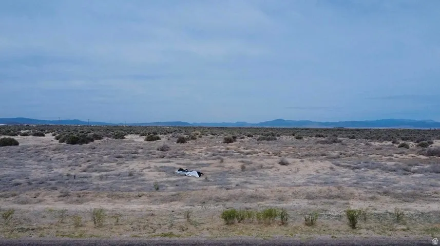 Expansive undeveloped land featuring natural desert vegetation and distant mountain ranges