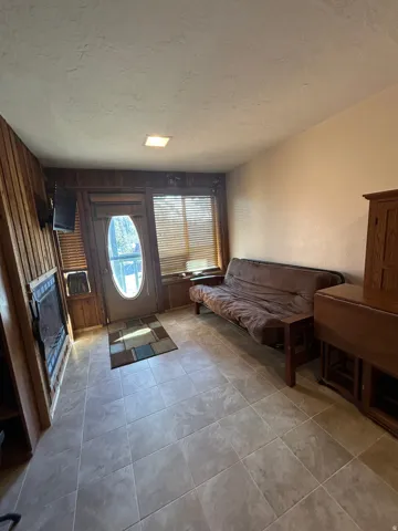 Entryway featuring wood-panel accent walls, tile flooring, and a recessed ceiling light