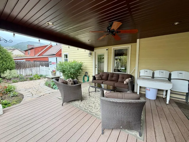 Expansive covered deck featuring composite decking, a ceiling fan, recessed lighting, and string lights