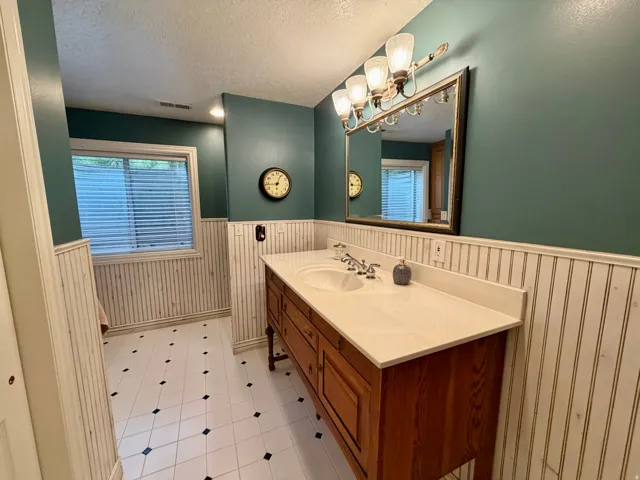 Double vanity with integrated sinks, light-toned countertop, and wood-finish cabinetry