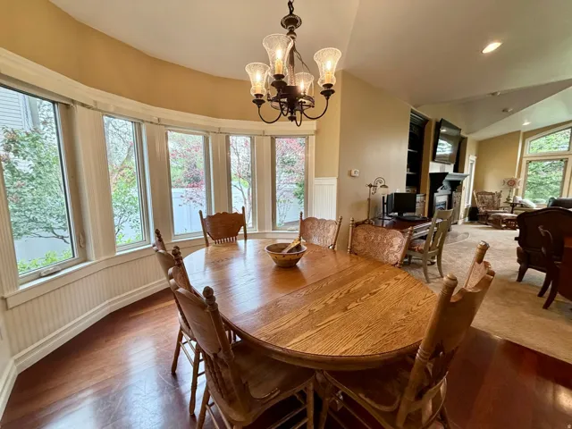 Dining area with a bay window, wood-finish flooring, and wainscoting