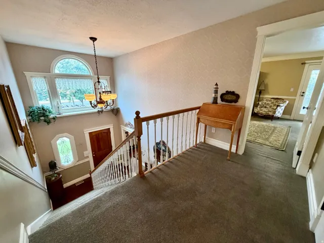 Two-story foyer featuring a chandelier, arched window, and decorative sidelight