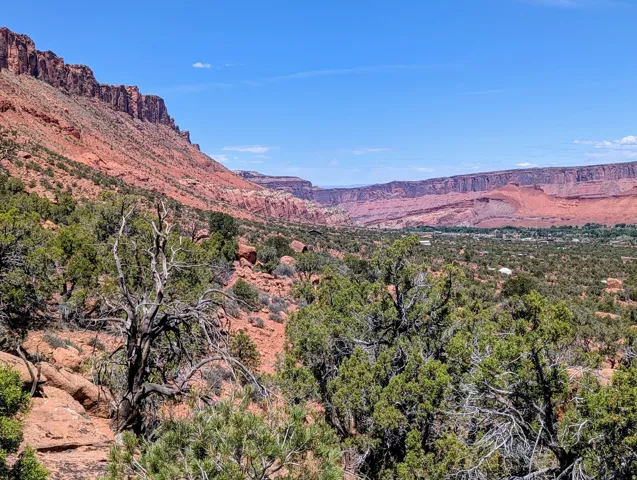 Expansive desert landscape featuring a prominent red rock mountain formation