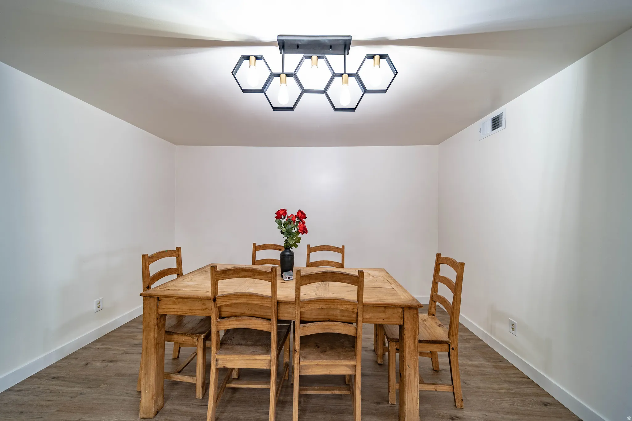 Recessed lighting enhances the bright white walls and wood-finish flooring