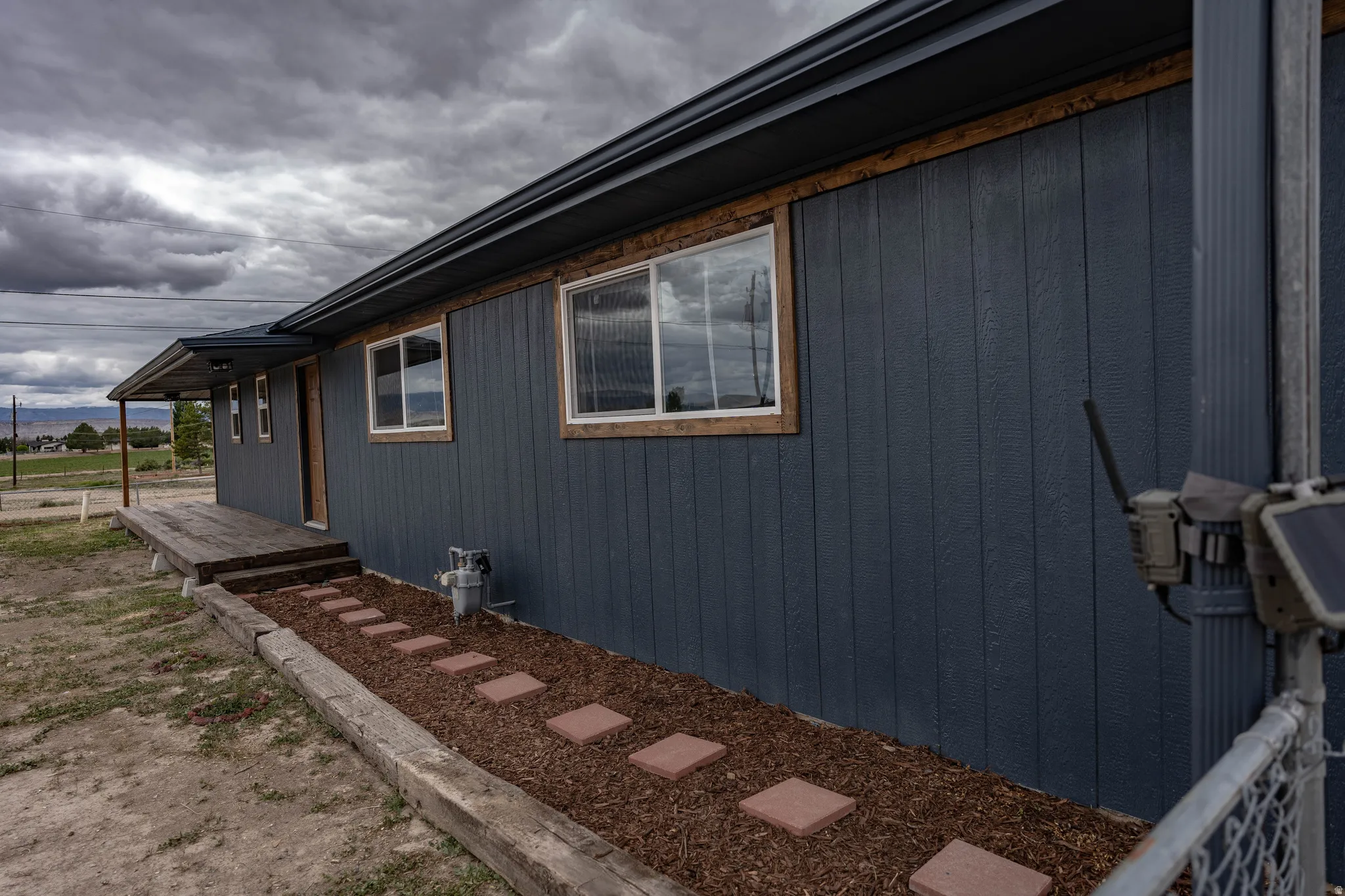 Exterior siding in a dark finish with contrasting wood-trimmed windows