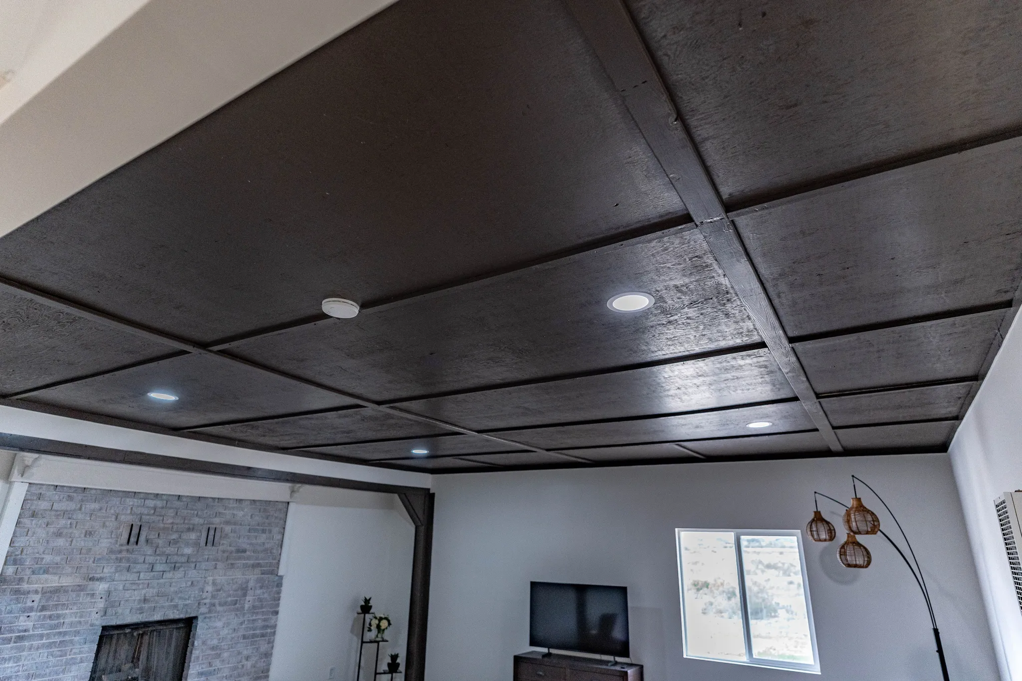 Coffered ceiling featuring dark-toned panels and recessed lighting