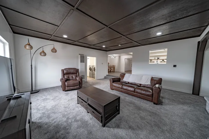 Spacious room featuring a dark wood-paneled ceiling with recessed lighting