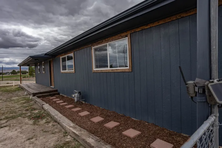 Exterior siding in a dark finish with contrasting wood-trimmed windows
