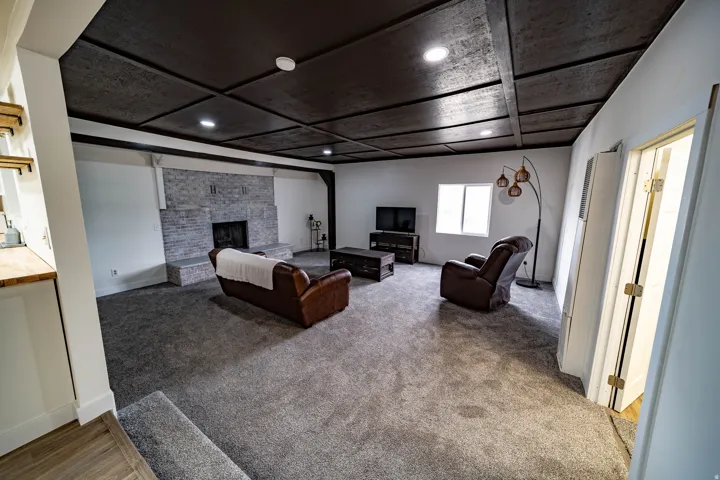 Spacious room featuring a textured coffered ceiling with recessed lighting