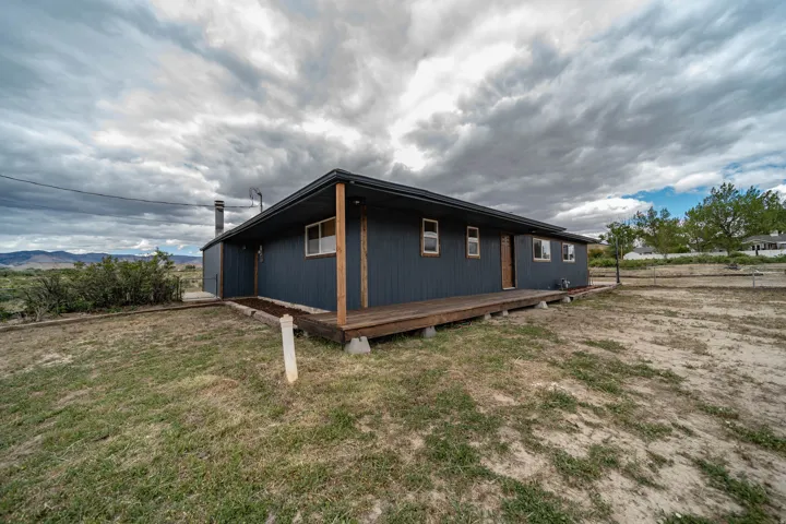 Dark-paneled exterior with contrasting wood trim and a full-length wooden deck