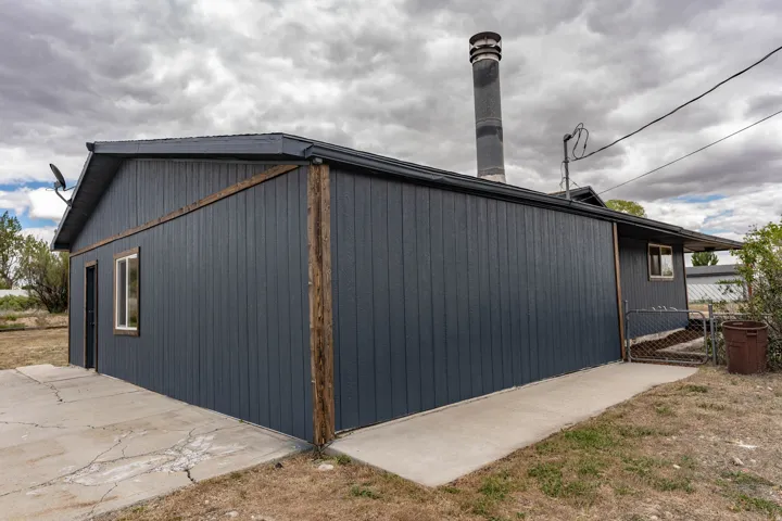Dark grey vertical board siding with wood trim accents