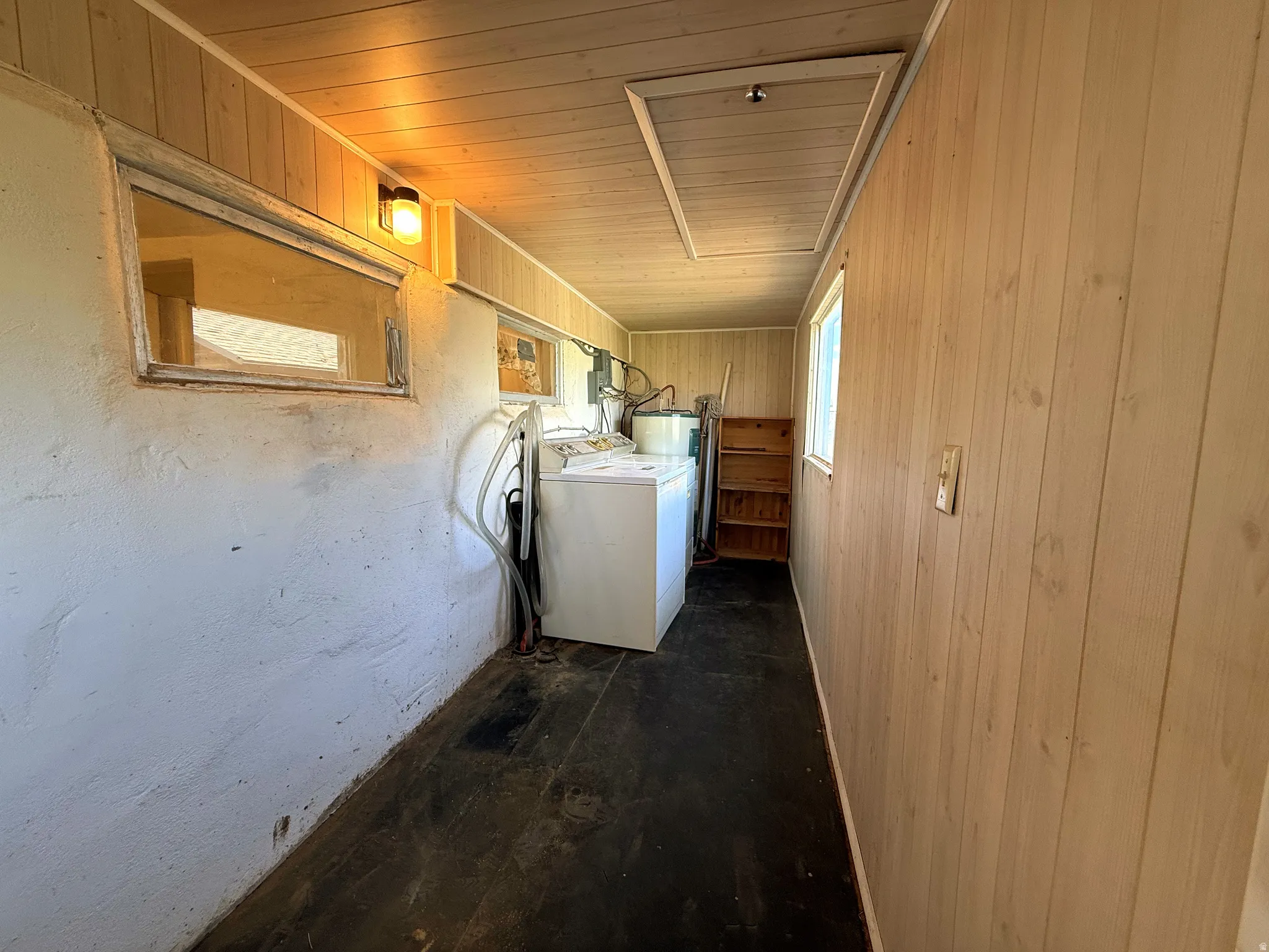 Utility room featuring a light wood-paneled ceiling and a white textured wall
