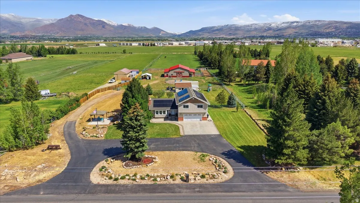 Two-story residence featuring a two-car garage, solar panels, and a paved driveway with a turn-around