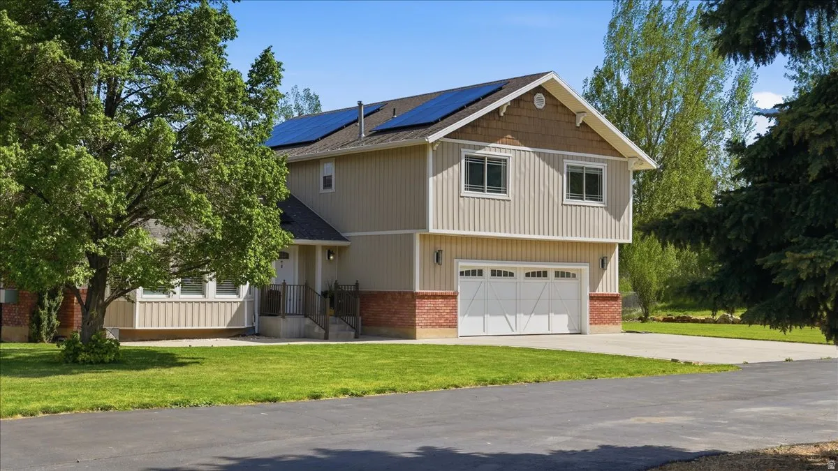 Two-story residence featuring light-colored vertical siding and brick accents