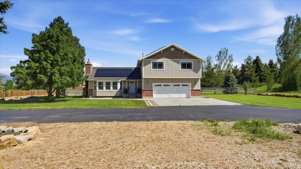 Two-story residence featuring light-toned siding, brick accents, and a dual-car garage