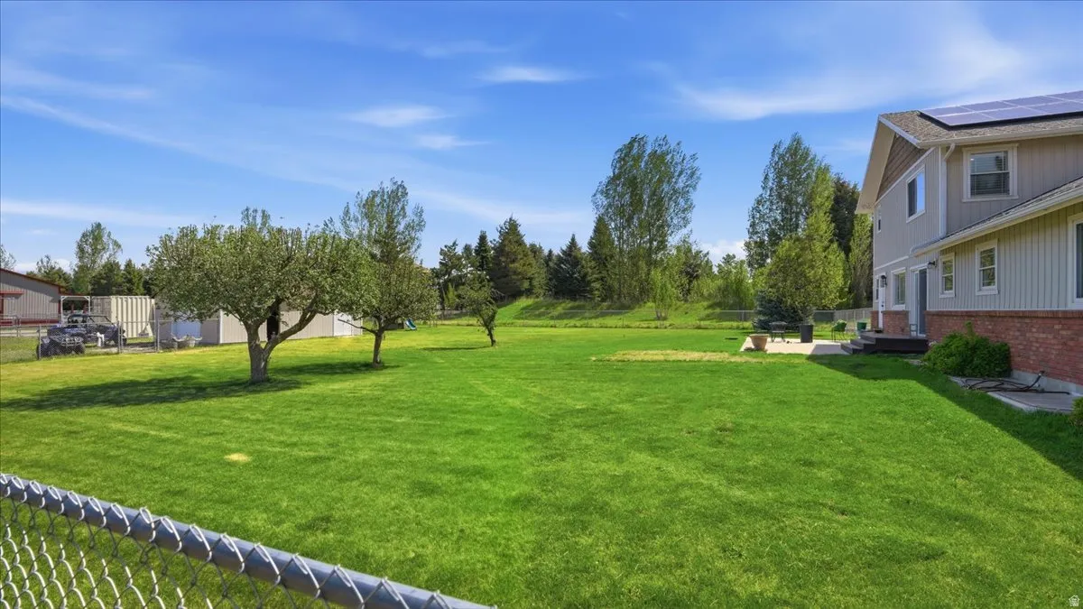 Expansive green lawn with mature trees and a private patio area